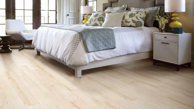 long planked wood look laminate flooring in a bright blonde tone in a bedroom
